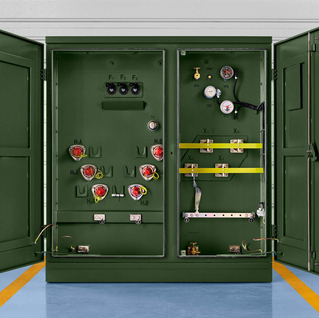 Open three-phase pad-mounted transformer showing primary and secondary sections